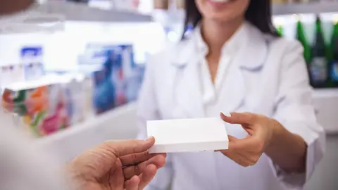 Farmacéutica administra un medicamento en el mostrador
