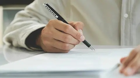 Hombre firma un documento (Foto: envato)