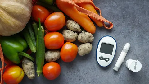 Aparato para la diabetes junto a verdura y fruta (Foto: envato)