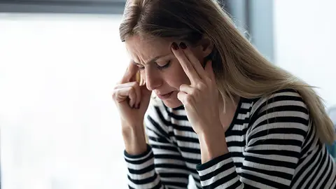 Mujer expresando dolor de cabeza (Foto: envato)
